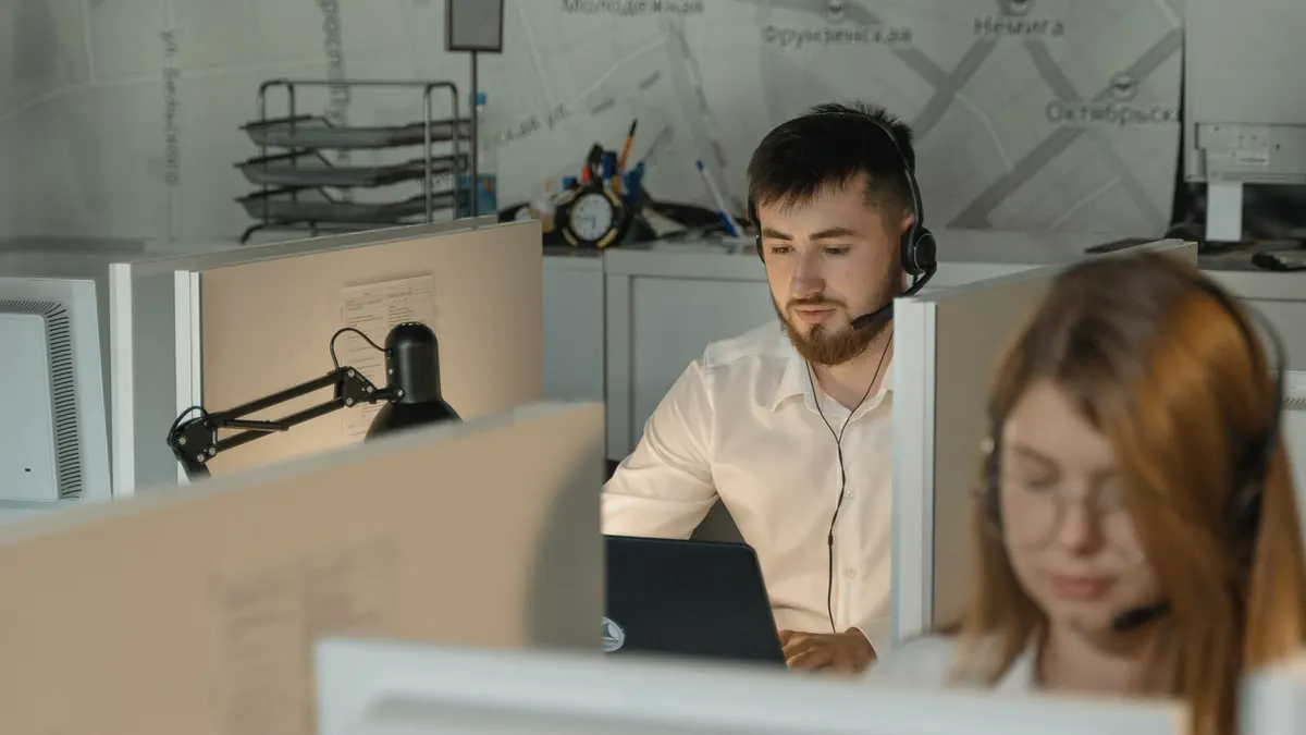 Office staff wearing headsets working at their computers